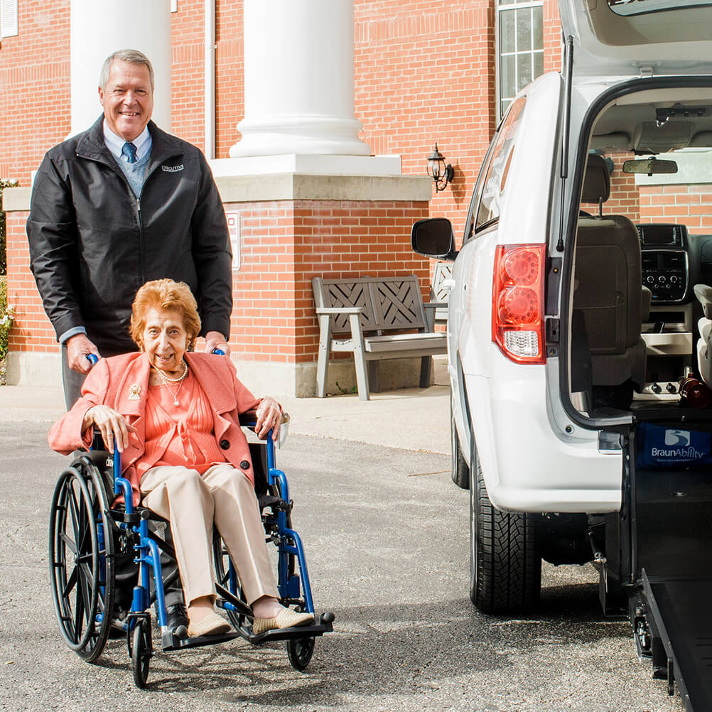 Man assisting older lady up ramp